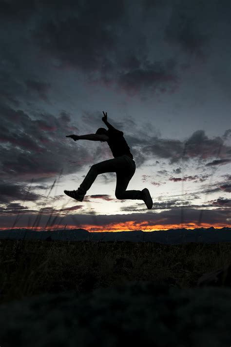 Hombre Saltando Suelo Nublado Cielo Dorado Fotografía De Hora