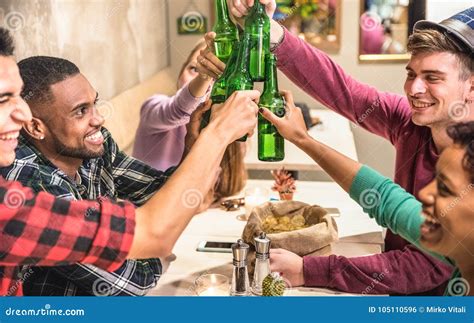 Multiracial Friends Group Drinking And Toasting Beer At Restaurant