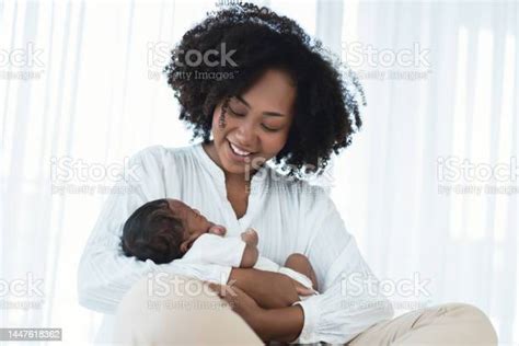 Smiling African American Mother Holding Newborn Baby In Her Arms Loving