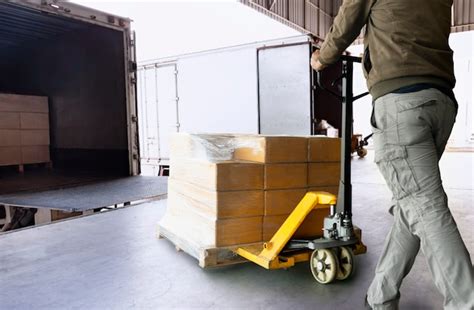 Premium Photo Warehouse Worker Unloading Pallet Shipment Goods Into A Truck Cargo Freight