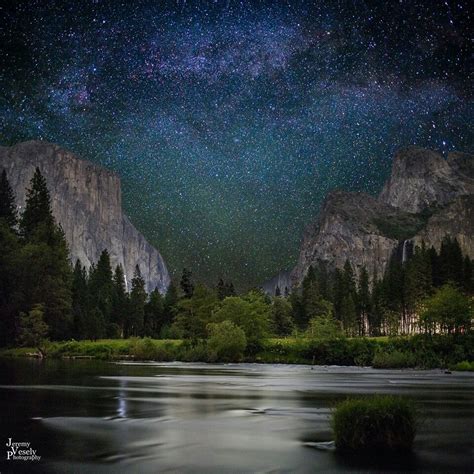 The Night Sky Is Filled With Stars Above Mountains And Trees As Well