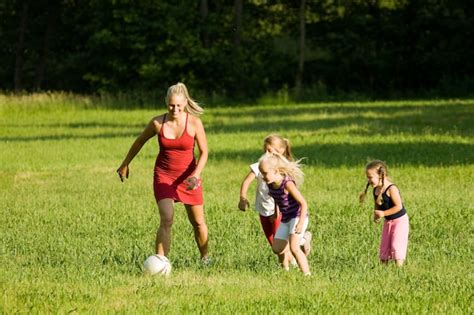 Familia Jugando Al Fútbol En Un Campo De Hierba Foto Premium