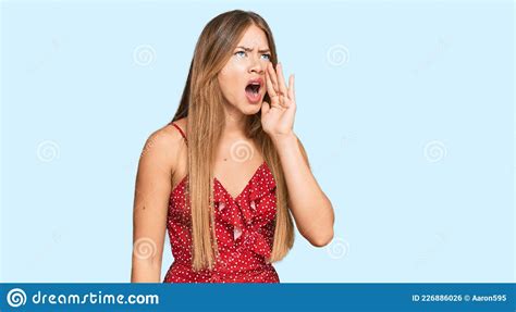 beautiful blonde woman wearing summer dress shouting and screaming loud to side with hand on