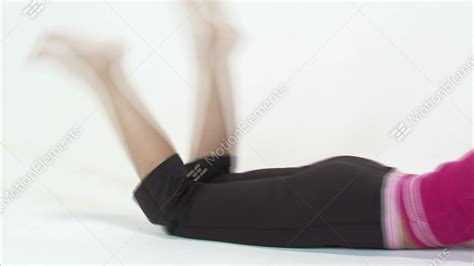 Pan Of A Woman Laying On Her Stomach Kicking Her Feet On A White Background Stock Video Footage