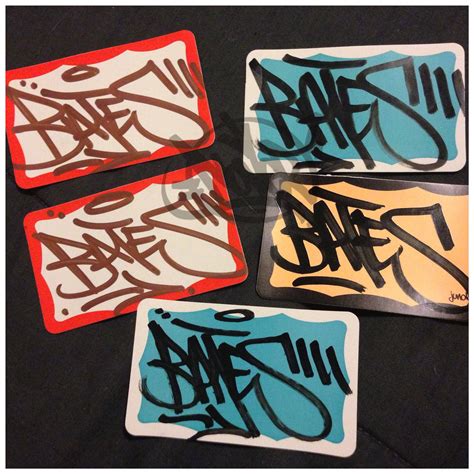 four coasters with graffiti on them sitting on a black table top in front of each other