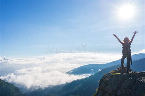 Woman With Arms Outstretched On Mountain Top Dramatic Landscape Clouds