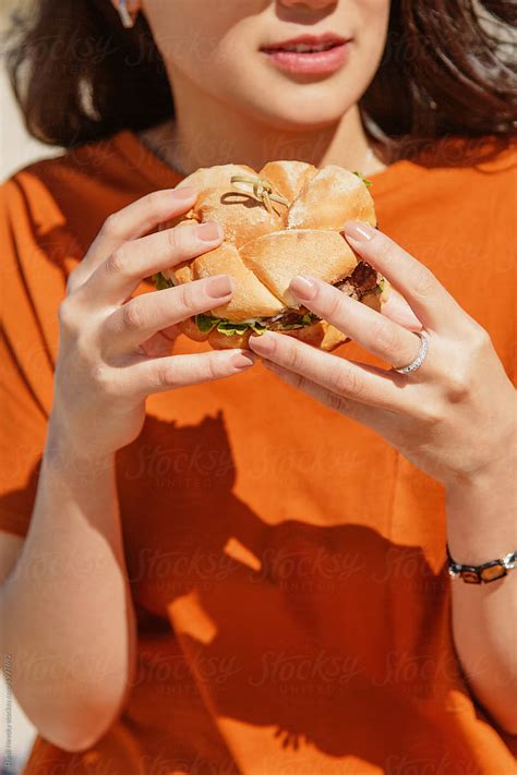 Beautiful Woman Holding Burger By Stocksy Contributor Danil Nevsky Stocksy