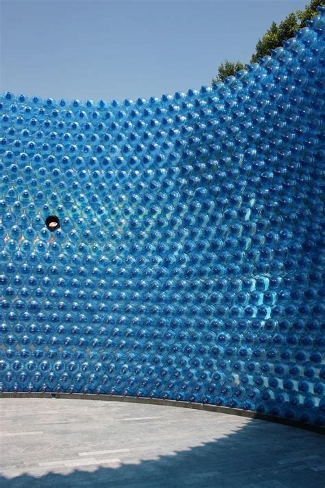 A Sculpture Made Out Of Plastic Bottles In Front Of A Blue Wall With