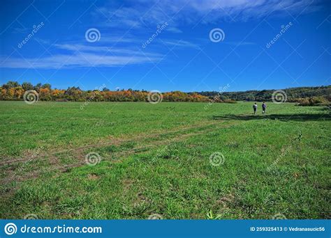 Two Hikers Walking Through The Green Valley Stock Image Image Of