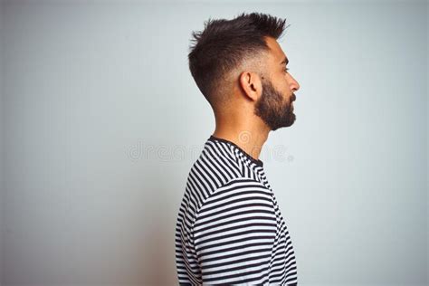 Young Indian Man Wearing Black Striped T Shirt Standing Over Isolated