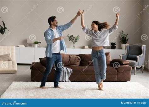 Full Length Loving Young Couple Dancing In Living Room Together Stock