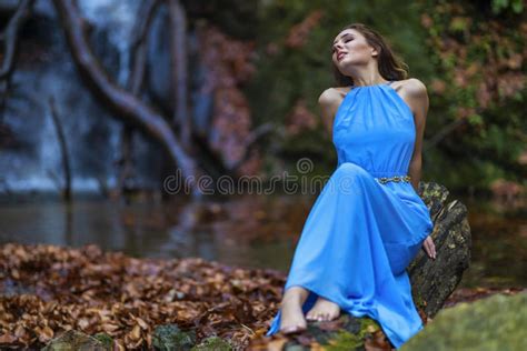 A Beautiful Woman In Blue Dress Near A Waterfall Stock Image Image Of