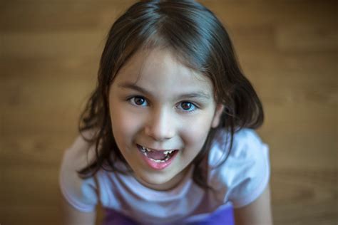 High Angle View Of A Happy Little Girl Looking At Camera With Toothy