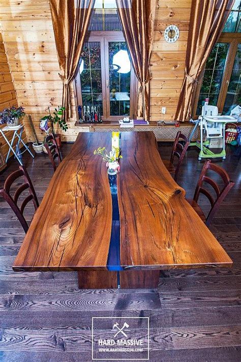 Wood has elegant and natural properties. A large modern dining table made of solid wood with a live ...