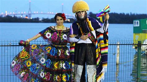 Two People Dressed In Colorful Clothing Standing Next To Each Other On