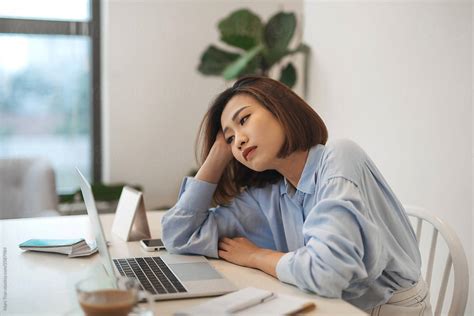 Bored Millennial Female Worker Lie At Office Desk By Marc Tran