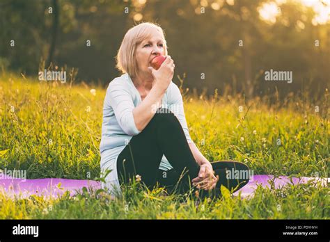 Active Senior Woman Eating Apple After Exerciseimage Is Intentionally