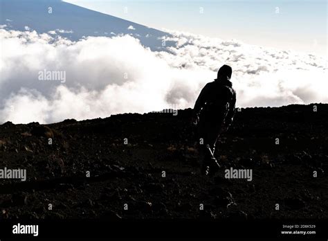 A Hiking Tourist Admiring Breathtaking View Of Mauna Kea Volcano On The