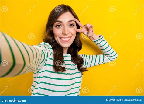 Photo Of Pretty Positive Person Toothy Smile Take Selfie Show V Sign Near Eye Isolated On Yellow