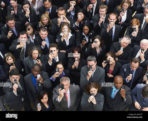 Large Group Of Business People Taking Photographs With Mobile Phones