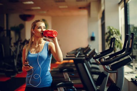 Beautiful Young Woman Resting And Drinking Water In The Gym Get
