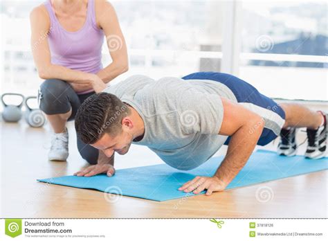 Trainer Helping Man With Push Ups Stock Photo Image Of Caucasian