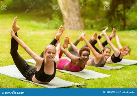 Diverse Millennial Girls Doing Bow Yoga Asana On Outdoor Group Practice
