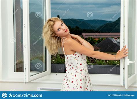 Beautiful Young Blonde Woman Standing Near The Window Stock Image