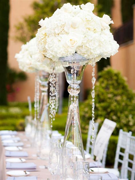 The Centerpieces Are Adorned With White Flowers And Crystal Beads