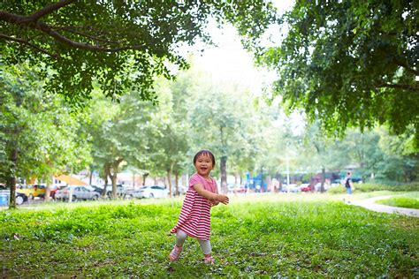 One Lovley Little Asian Girl Playing In The Park Under The Tree Del Colaborador De Stocksy Bo