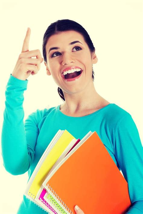 Young Happy Female Student Pointing Up Holding Workbooks Stock Photos