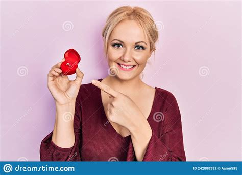 Young Blonde Woman Wearing Engagement Ring Smiling Happy Pointing With Hand And Finger Stock