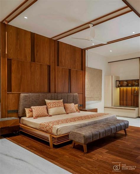 A Large Bed Sitting On Top Of A Wooden Floor Next To A Wall Mounted Mirror