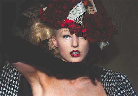 Extravagant young woman in creative costume and headwear looking at ...