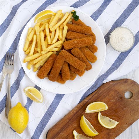 Homemade Fish Sticks And Fries With Tartar Sauce On A White Wood Food