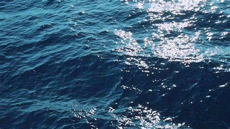 Slow Mo. Beautiful sunlit blue sea waves. Real water ripple on the surface of the sea. Close up ...
