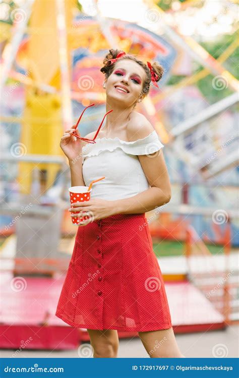 A Young Happy Woman With Bright Makeup Is Holding Red Rimmed Glasses And Having Fun At An