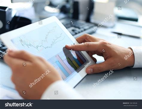 Business Person Analyzing Financial Statistics Displayed On The Tablet ...