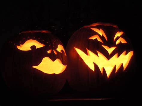 Two Carved Pumpkins Sitting On Top Of A Table