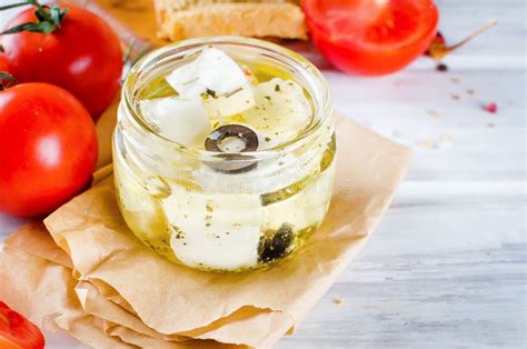 Feta Cheese Marinated In Olive Oil With Fresh Herbs In Glass Jar Stock
