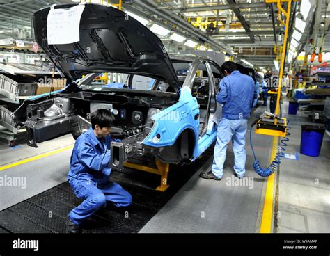 Chinese Factory Workers Assemble Roewe 350 Cars On The Assembly Line At