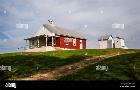 Historic Red Brick Amish One Room Schoolhouse Exterior And Outhouses In