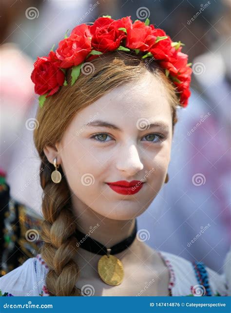 Beautiful Young Woman Wearing A Flower Headdress And Traditional Romanian Folk Costume During