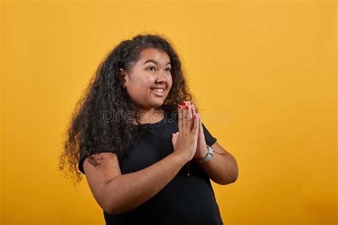 Cheerful Woman With Overweight Keeping Hands Together Praying Looking Aside Stock Image
