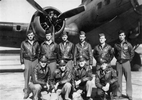 A Group Of Men Standing Next To Each Other In Front Of An Airplane