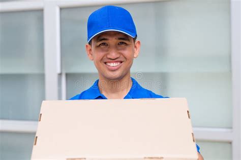 Delivery Man Carrying A Parcel Box And Giving Thumbs Up Stock Image