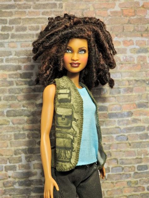 A Doll Is Standing In Front Of A Brick Wall Wearing A Green Vest And