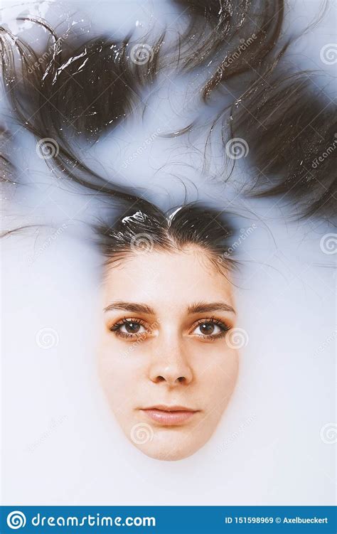 Beauty Portrait Of Young Woman Face And Hair Floating In Milk Bath