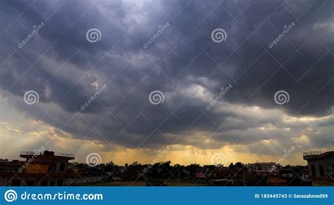 Heavenly Sun Rays Through Dark Clouds Against The Blue Sky Stock Image