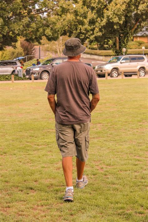 A Man Walking Across A Lush Green Field